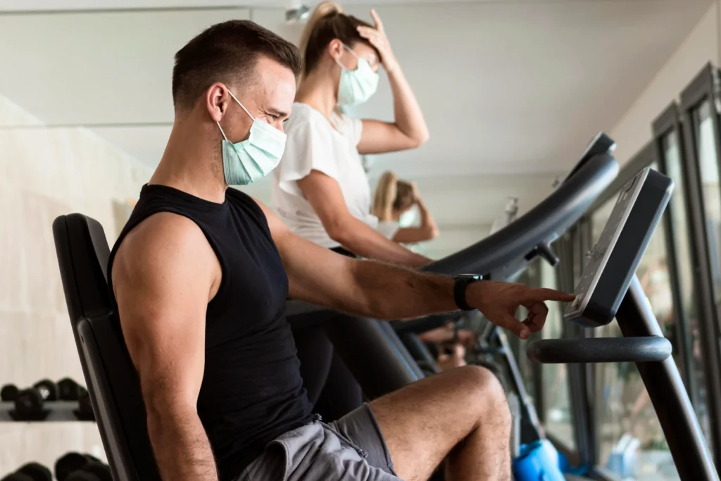 Persona entrenando con tapabocas en el gimnasio — ¿entrenar enfermo? — Team Sport Balance